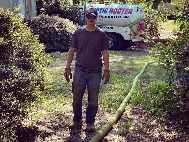 SepticRooter technician on site with the vacuum hose run out to the tank